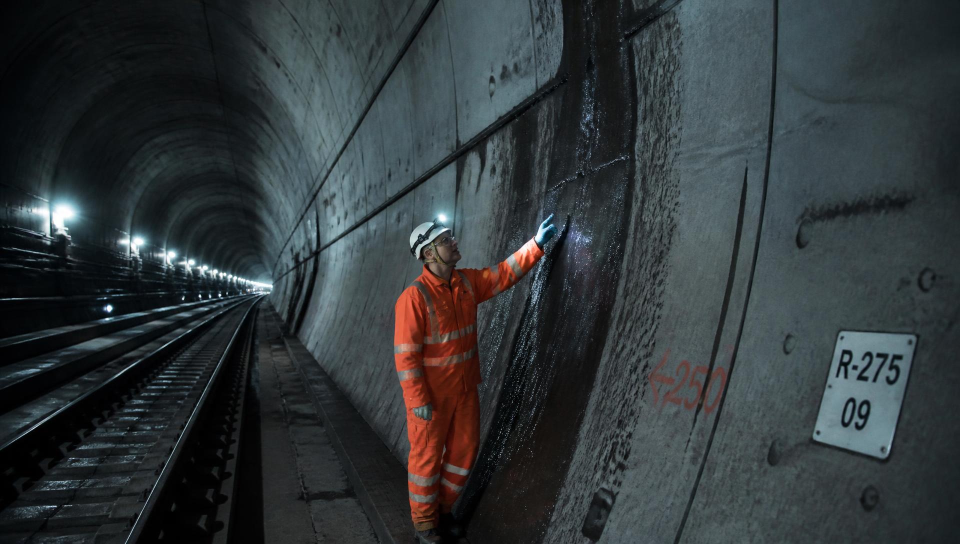 Engineer inspecting water ingress on a rail tunnel lining